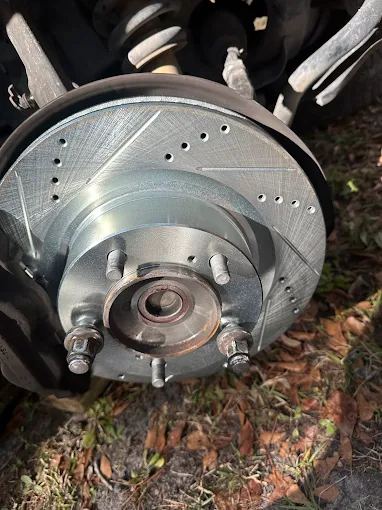 New drilled and slotted brake rotor mounted on a front hub